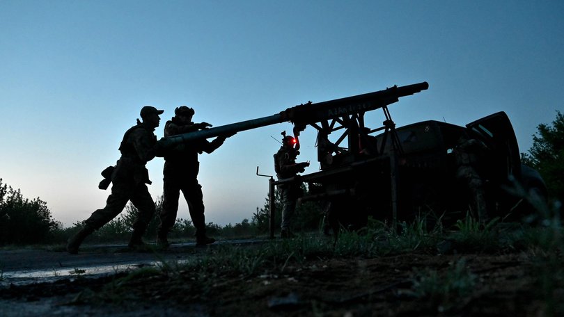 Ukrainian servicemen load Grad rocket launch tubes.