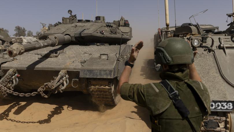 An Israeli soldier directs a tank near the border with the southern Gaza Strip.