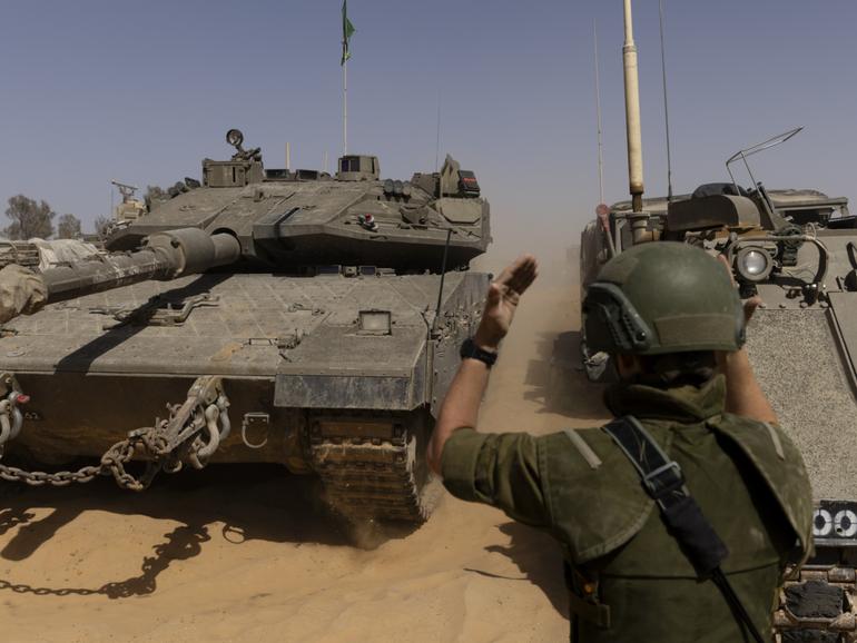 An Israeli soldier directs a tank near the border with the southern Gaza Strip.