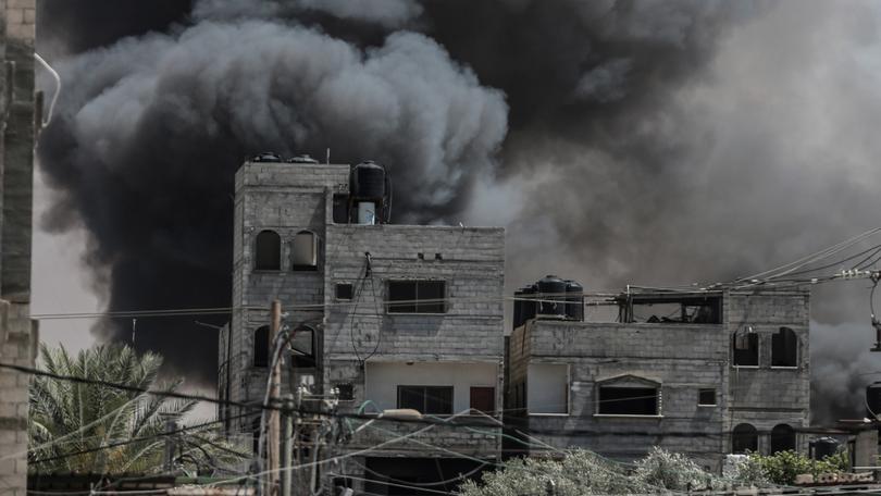 Smoke rises from a shopping centre following an Israeli airstrike on the east of Rafah.