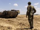 An Israeli soldier walks near an armoured personnel carrier near the border with the southern Gaza Strip.