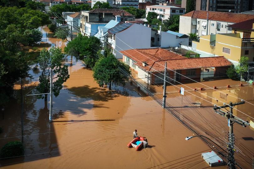 PORTO ALEGRE, BRAZIL - MAY 07: Aerial view, Rescue team members walk through the flooded streets as rescue efforts continue at the Menino Deus neighborhood on May 7, 2024 in Porto Alegre, Brazil. Rescue efforts continue in Porto Alegre due to the floods caused by the heavy rains that have battered Brazilian State of Rio Grande Do Sul. A State of Public Calamity has been called by local government while 281 municipalities have been affected, thousands of people have been displaced and damages in infrastructure cause difficulties to access affected areas or big power outages around the state. (Photo by Jefferson Bernardes/Getty Images) *** BESTPIX ***