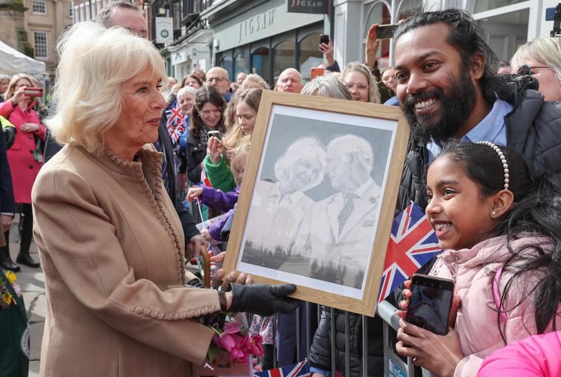 Queen Camilla receives artwork of herself and King Charles III from well-wishers during her visit to Shrewsbury.