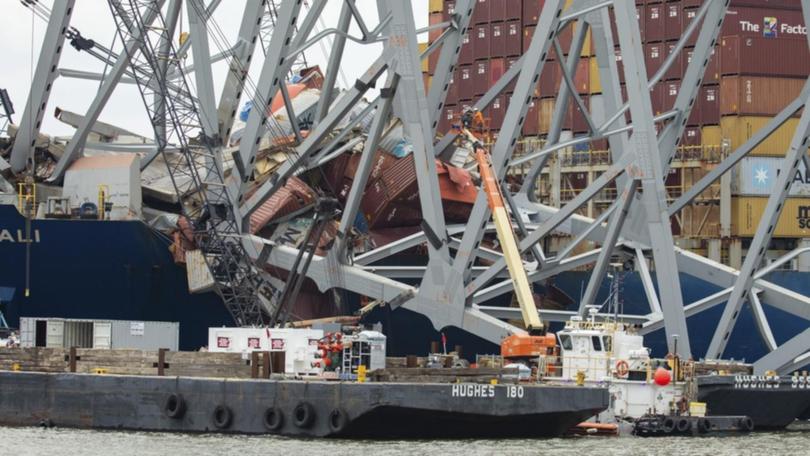 Salvors are preparing charges to remove a section of wreckage from a collapsed bridge in Baltimore. 
