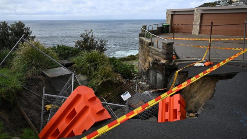 Council workers are fixing a 10-metre sinkhole on an east Sydney street caused by heavy rain. (Dean Lewins/AAP PHOTOS)