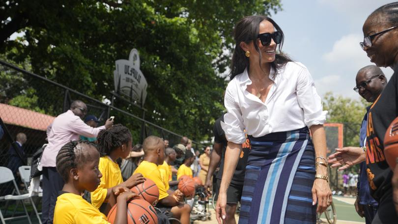 Meghan Markle, center, Speaks with a woman during the Giant of Africa Foundation at the Dream Big Basketball clinic in Lagos Nigeria, Sunday, May 12, 2024. Prince Harry and his wife Meghan are in Nigeria to champion the Invictus Games, which Prince Harry founded to aid the rehabilitation of wounded and sick servicemembers and veterans. (AP Photo/Sunday Alamba)