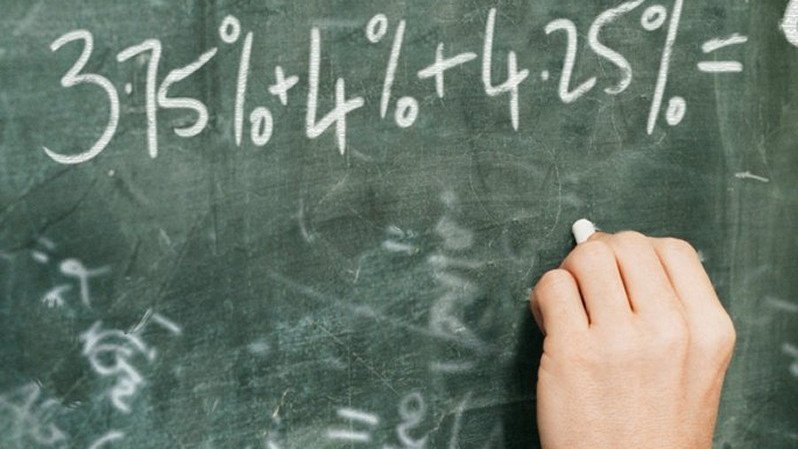 Teacher writing on a blackboard.