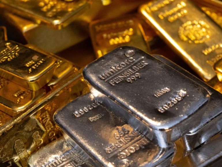 Gold and silver bars of various sizes lie in a safe on a table at the precious metals dealer Pro Aurum in Munich.