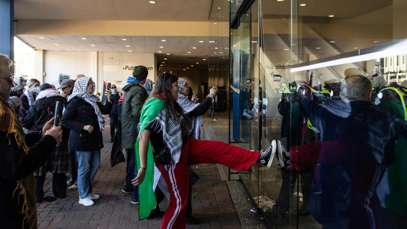 Pro-Palestine protesters kick the main entrance the ALP Conference occurs inside. NCA NewsWire / Diego Fedele