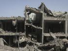 Palestinians look at the destruction after an Israeli strike on a building in Nuseirat camp, Gaza. (AP PHOTO)
