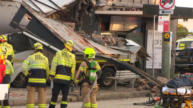 A driver is trapped after a truck crashed into a suburban home.