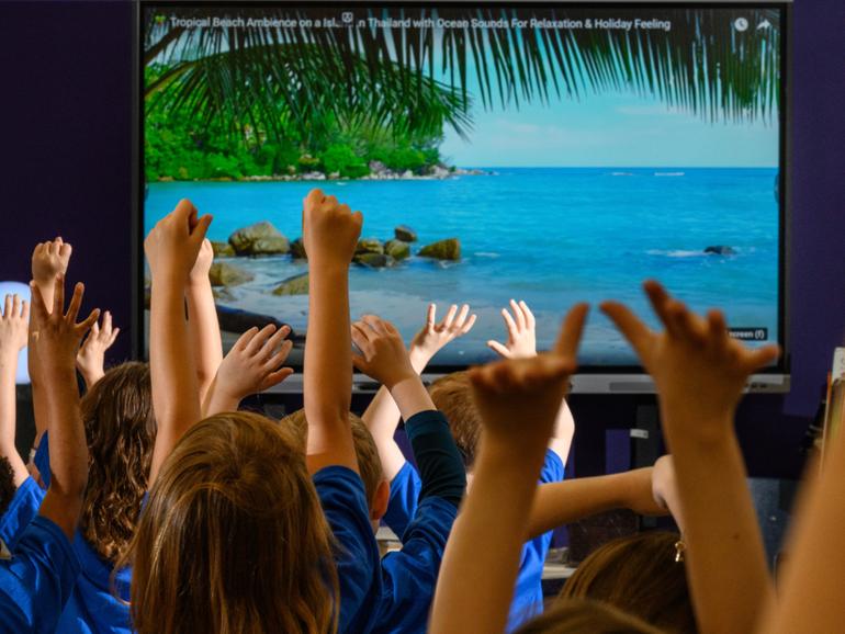 Students practice yoga during a mental health fair at Woodsdale Elementary School in Wheeling, W.Va., April 19, 2024. A Woodsdale Elementary counselor said the schools mental health fair is valuable precisely because it is universal, and troubled children are not singled out. 