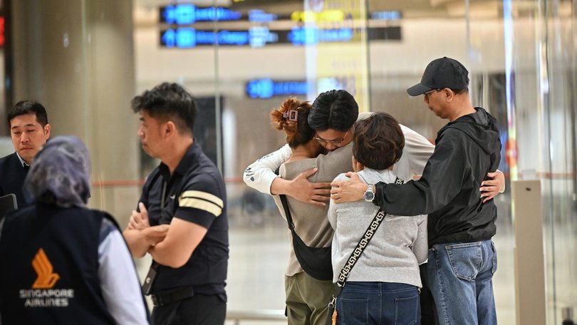 Familes embrace at Sydney Airport on arrival from Thailand.