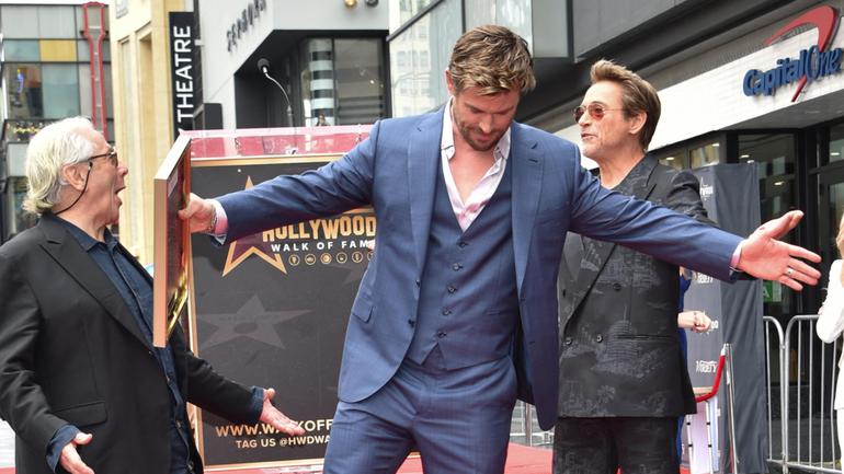 Australian filmmaker George Miller (left) and US actor Robert Downey Jr. (right) pose with Chris Hemsworth during his Walk of Fame ceremony in Hollywood.