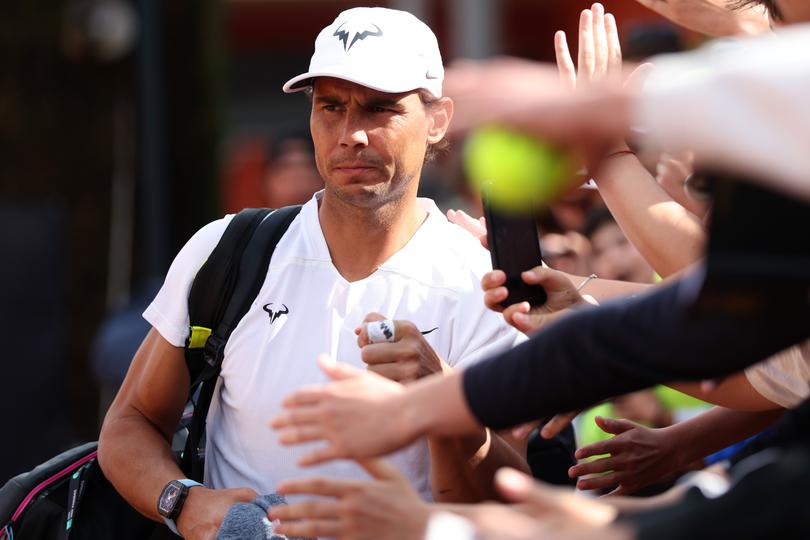 Rafael Nadal of Spain greets the waiting fans as he walks out for a practice session.