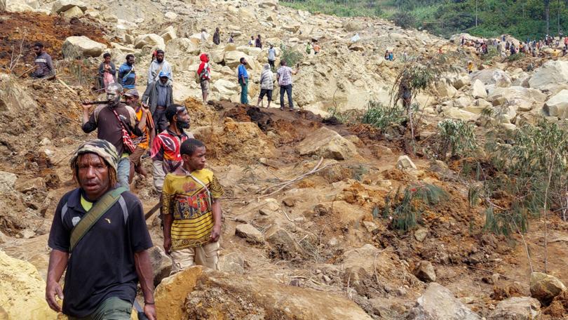 Locals gather at the site of a landslide at Mulitaka village in the region of Maip Mulitaka, in Papua New Guinea's Enga Province on May 26, 2024. More than 670 people are believed dead after a massive landslide in Papua New Guinea, a UN official told AFP on May 26 as aid workers and villagers braved perilous conditions in their desperate search for survivors. (Photo by AFP)