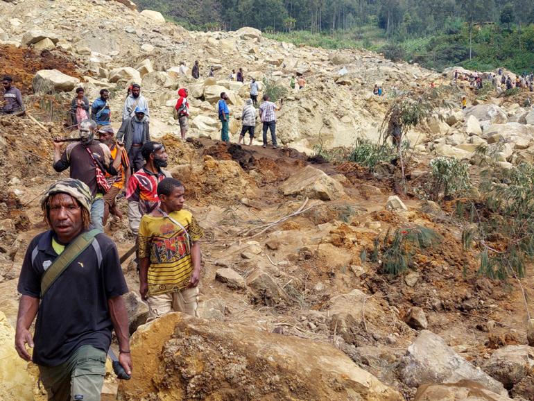 Locals gather at the site of a landslide at Mulitaka village in the region of Maip Mulitaka, in Papua New Guinea's Enga Province on May 26, 2024. More than 670 people are believed dead after a massive landslide in Papua New Guinea, a UN official told AFP on May 26 as aid workers and villagers braved perilous conditions in their desperate search for survivors. (Photo by AFP)