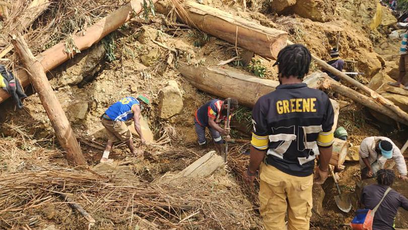 People continue to work at the scene of a deadly landslide in the province of Enga, 600 kilometres north-west of Port Moresby.