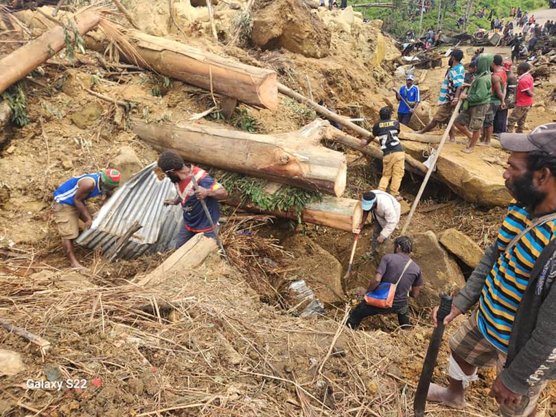 Locals work at the scene of the deadly landslide in Enga.