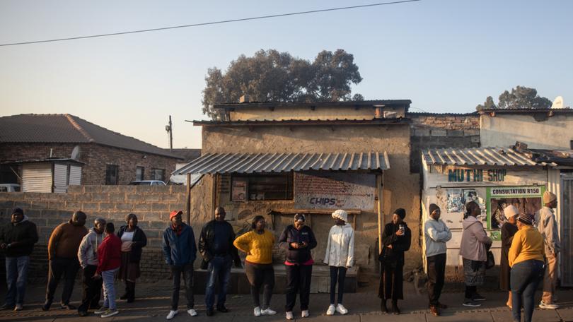 People wait in line to cast their votes in Alexandra township in Johannesburg, 