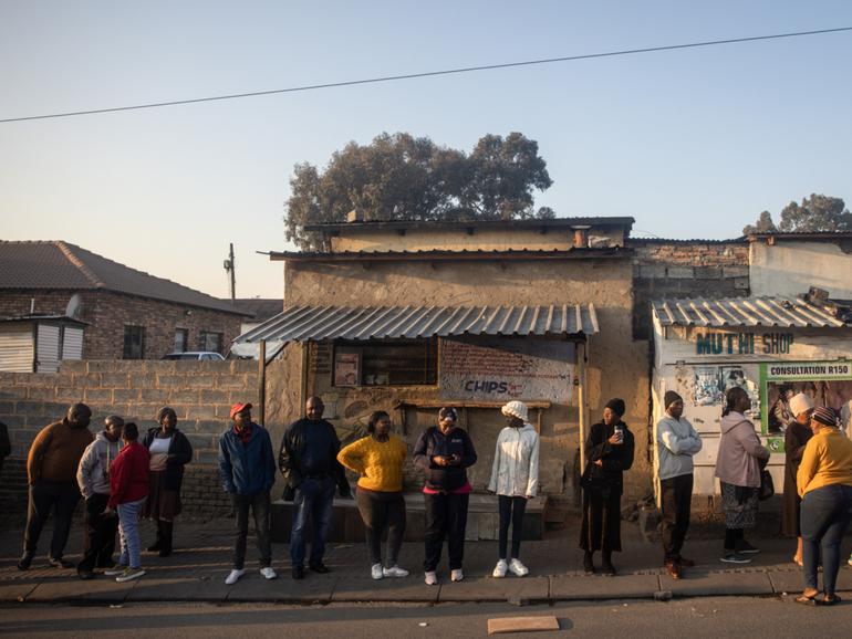 People wait in line to cast their votes in Alexandra township in Johannesburg, 