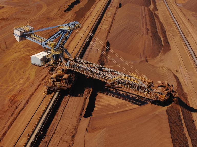 An aerial view of a reclaimer used to harvest crushed iron ore stockpiles on a mine site. Dazman