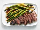Butter-basted steak with asparagus. When this simple steak gets a quick butter baste, its center cooks gently and evenly, and its outside develops a beautiful bronze crust sticky with ginger, garlic and herbs. Food styled by Simon Andrews. (David Malosh/The New York Times)