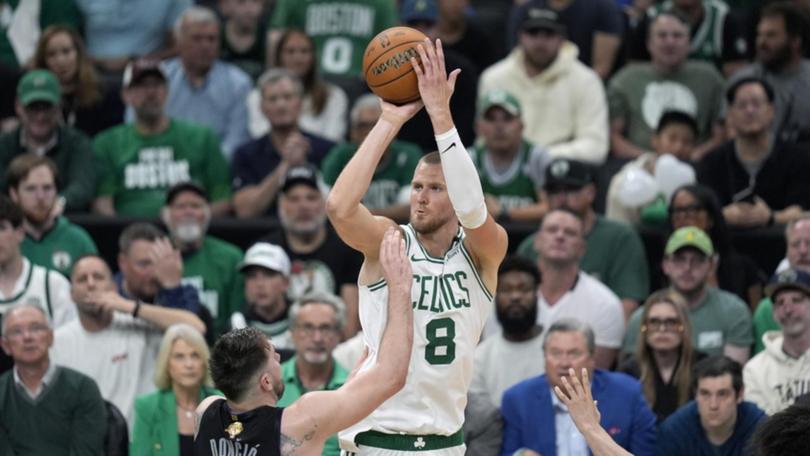 Boston centre Kristaps Porzingis shoots over Dallas guard Luka Doncic in their 18-point win. (AP PHOTO)