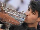 Carlos Alcaraz kisses the trophy after winning the French Open, his third grand slam triumph.