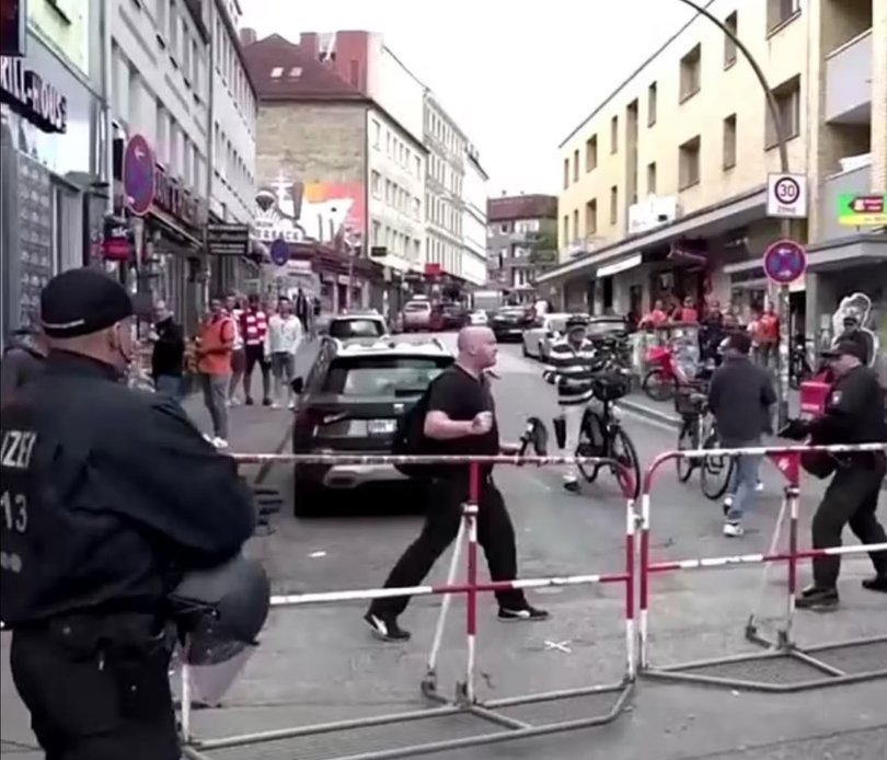 Police have neutralised a suspect with an axe near a fan complex at the famous Reeperbahn in Hamburg, where thousands of fans are gathering today due to the match between the national teams of Holland and Poland.
pictured: This is the dramatic moment armed German police close in on an axeman near a Euros fan zone today before shooting him
