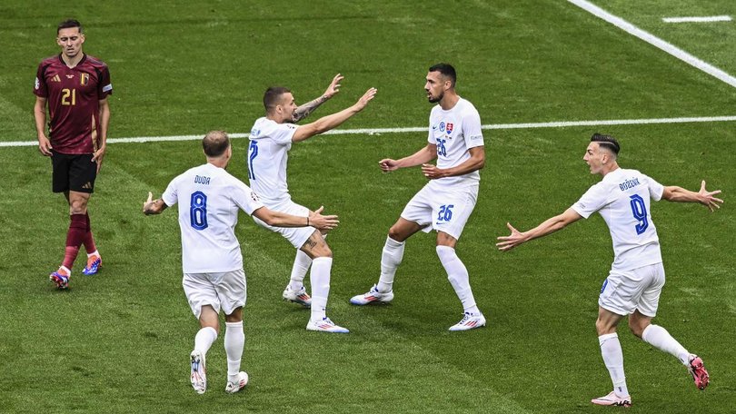 Slovakia players run to Ivan Schranz (26) after he scored the surprise winner against Belgium.