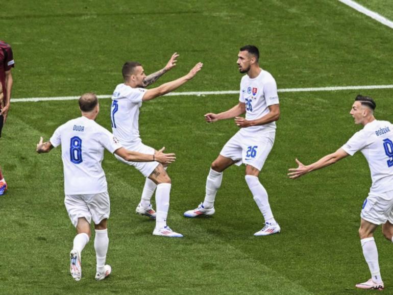 Slovakia players run to Ivan Schranz (26) after he scored the surprise winner against Belgium.