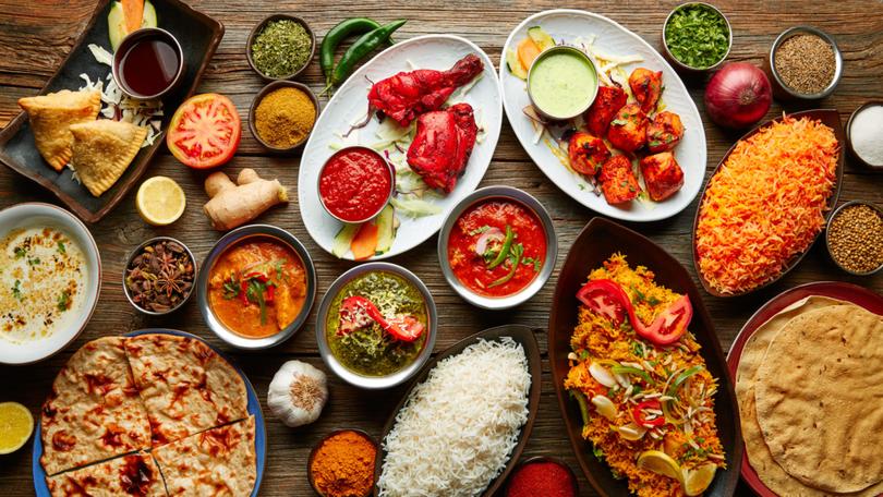 Assorted Indian recipes food various with spices and rice on wooden table