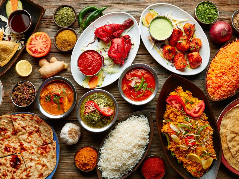 Assorted Indian recipes food various with spices and rice on wooden table