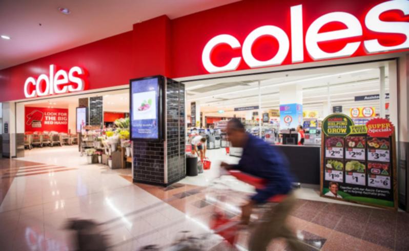 A shopper pushes a trolley outside a Coles supermarket in Sydney.