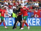 Cristiano Ronaldo of Portugal reacts after a pitch invader attempts to take a selfie photograph with him.