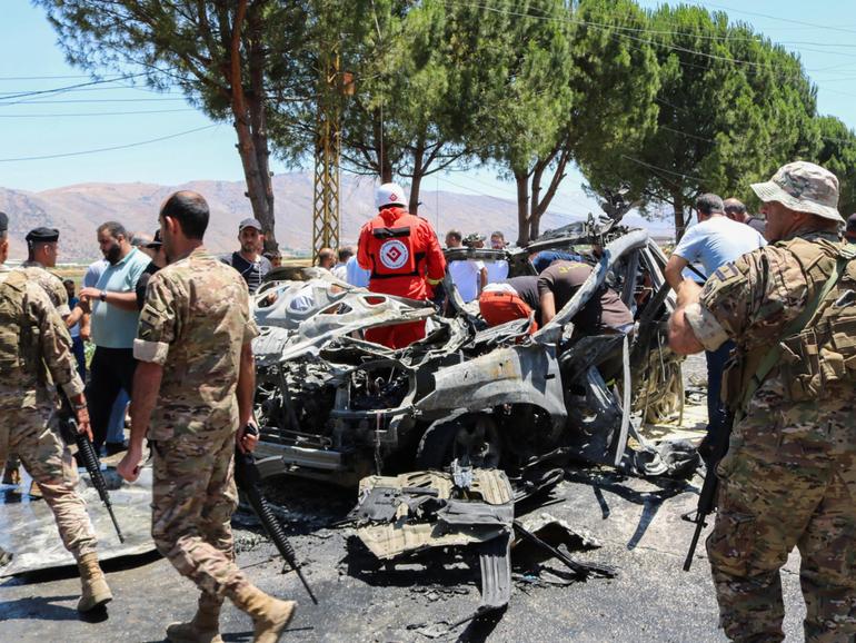 Emergency service members gather around a car destroyed in an Israeli strike targeting a Jamaa Islamiya member in in Lebanon's Western Bekaa area on the weekend.