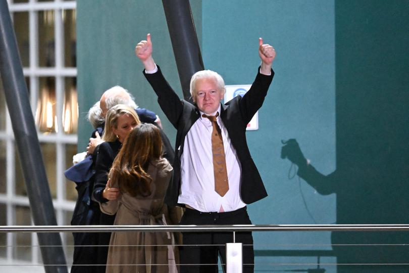 Assange waves at supporters.