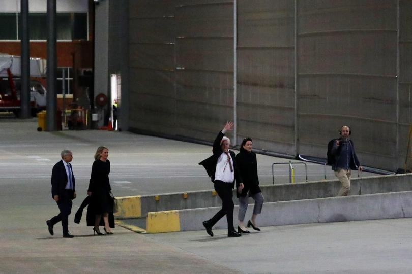 WikiLeaks founder Julian Assange waves as he arrives at Canberra Airport.