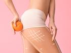 Young woman with orange fruit on color background. Concept of cellulite