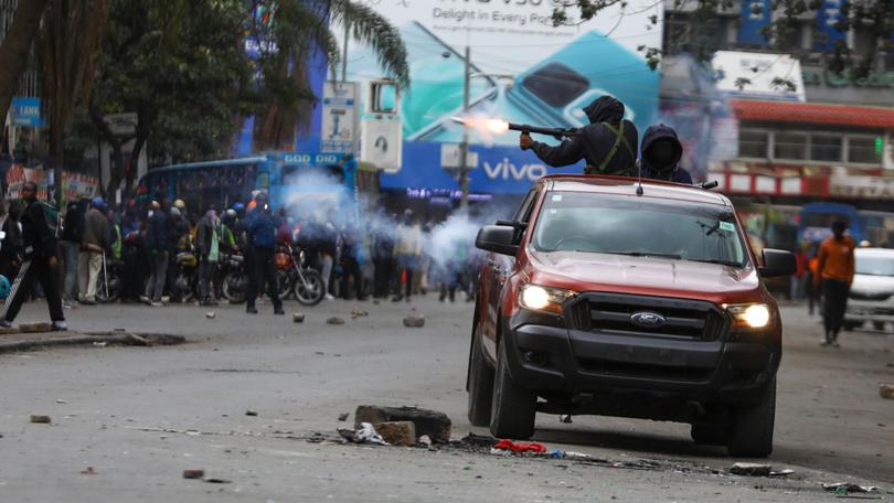 A police officer fires teargas as protests continued against the government of President William Ruto in Nairobi. 