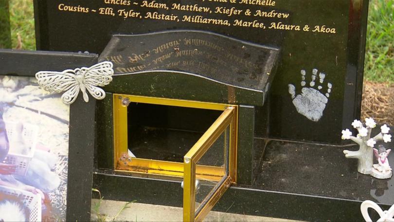 The tiara was locked in a box, behind a glass door, built into the headstone.