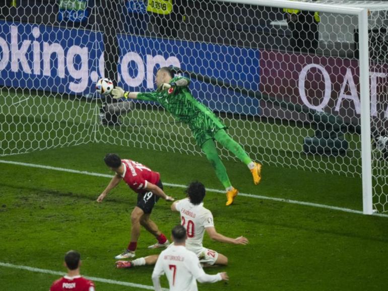 Turkey goalkeeper Mert Gunok leaps to his right to claw away Christoph Baumgartner's (19) header. (AP PHOTO)