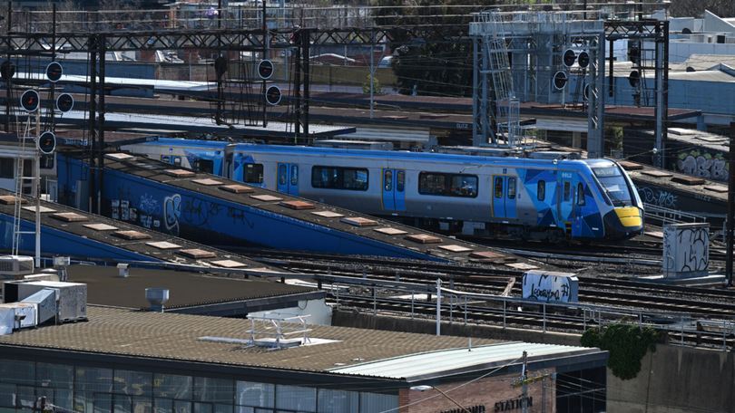 Police are searching for a man who pushed a woman onto train tracks in Melbourne.