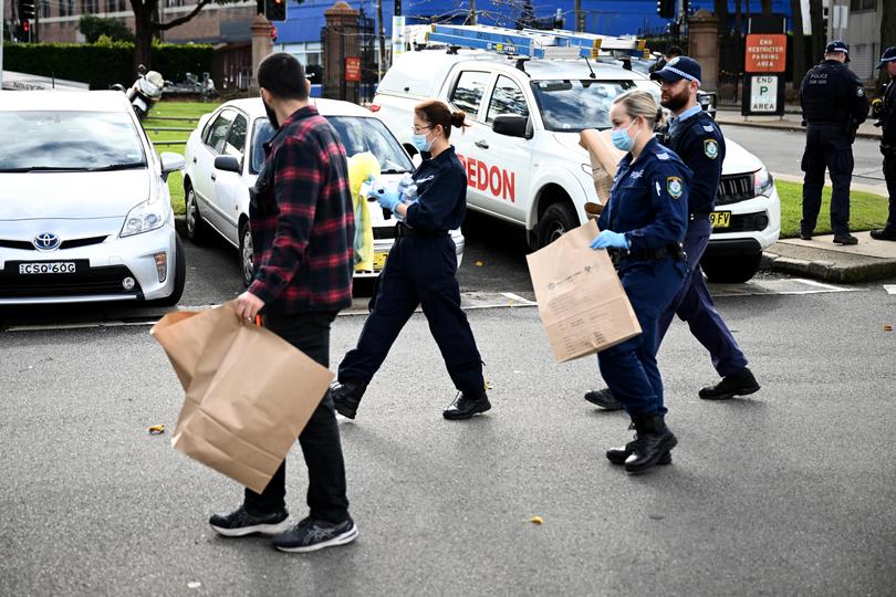 NSW Police and Forensic investigators carry bagged items at the scene of an alleged stabbing at University of Sydney, in Sydney, Tuesday, July 2, 2024. (AAP Image/Dan Himbrechts) NO ARCHIVING DAN HIMBRECHTS