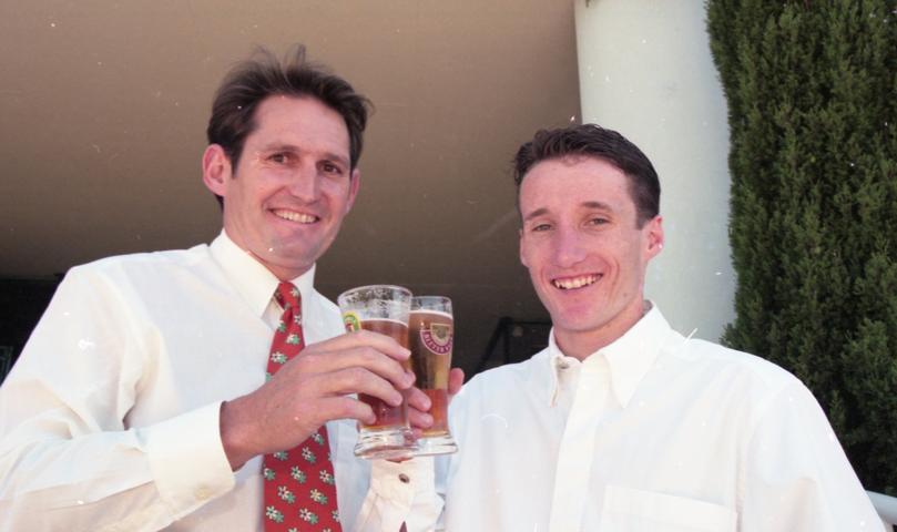 Champion jockey Damien Oliver (right), with his business manager Neil Pinner, share a Christmas drink after the jockey arrived in Perth yesterday.
December 20, 1996. Picture: Barry Baker, The West Australian