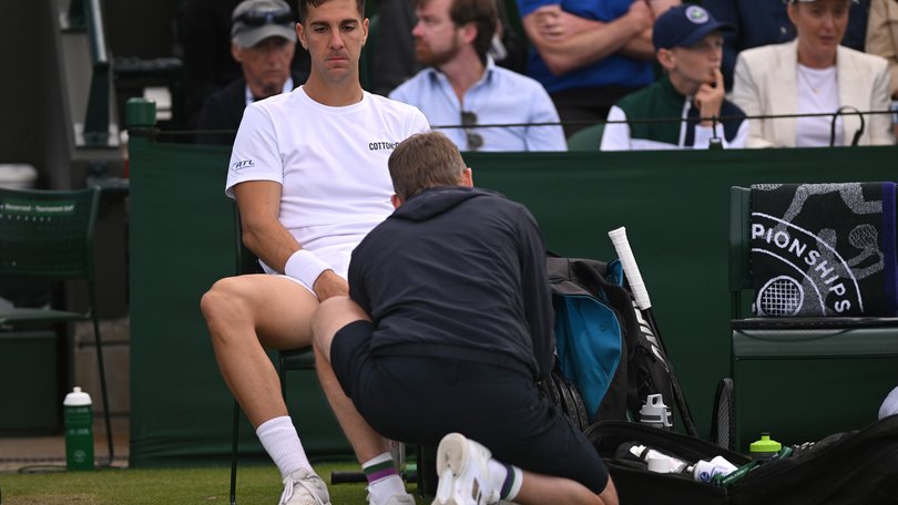 Thanasi Kokkinakis of Australia receives medical treatment before retiring injured during in his  second round match against Lucas Pouille.