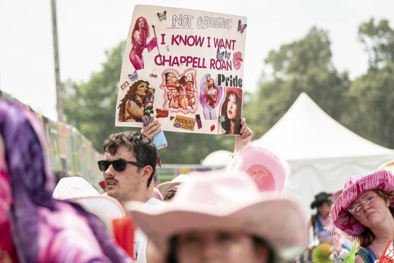 A festivalgoer holds a sign for Chappell Roan.