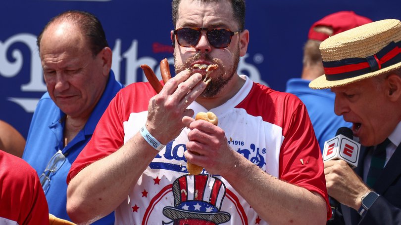 Patrick Bertoletti downs one his 58 hot dogs.