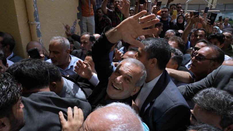 Masoud Pezeshkian (centre) has been declared the winner of Iran's presidential election.  (AP PHOTO)